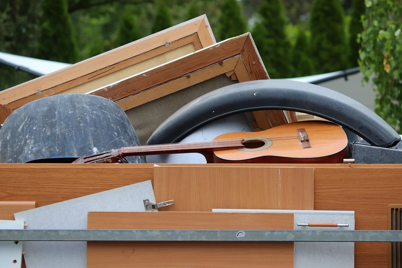 Zwei Mitarbeiter bewegen ein Sofa aus einer Wohnung.